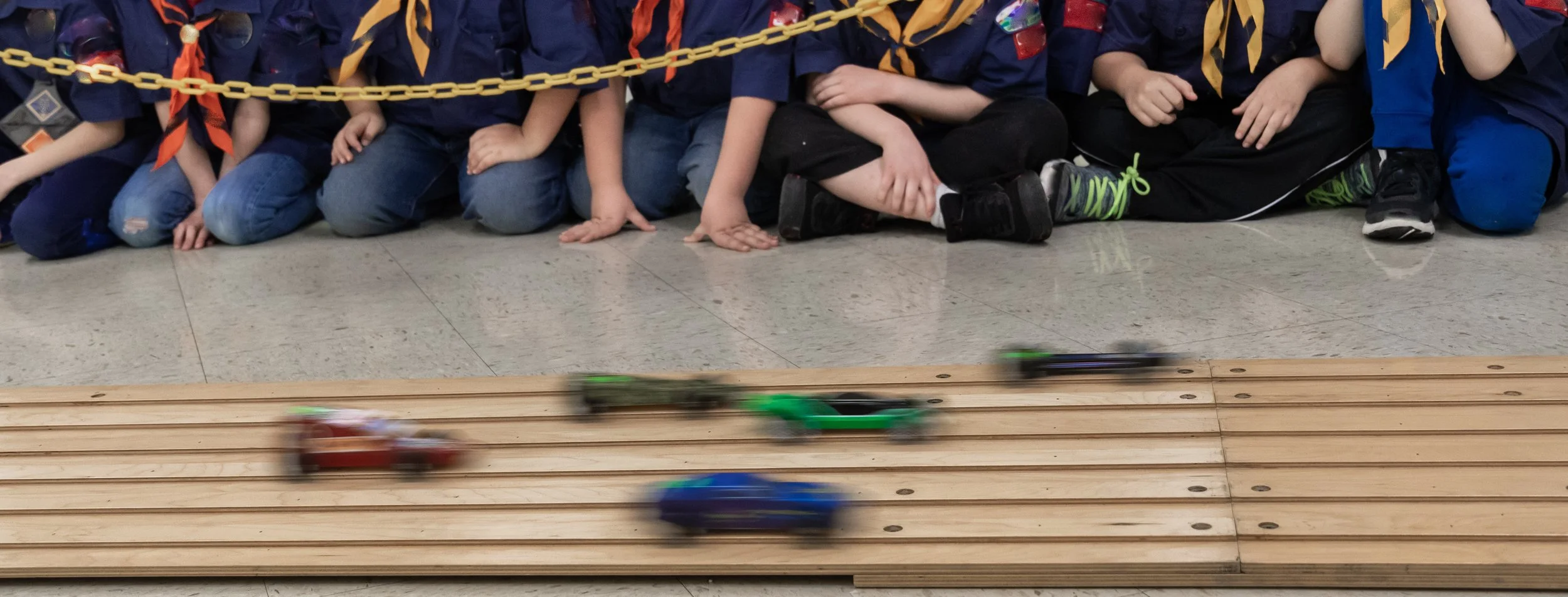 Pinewood derby cars racing on a track